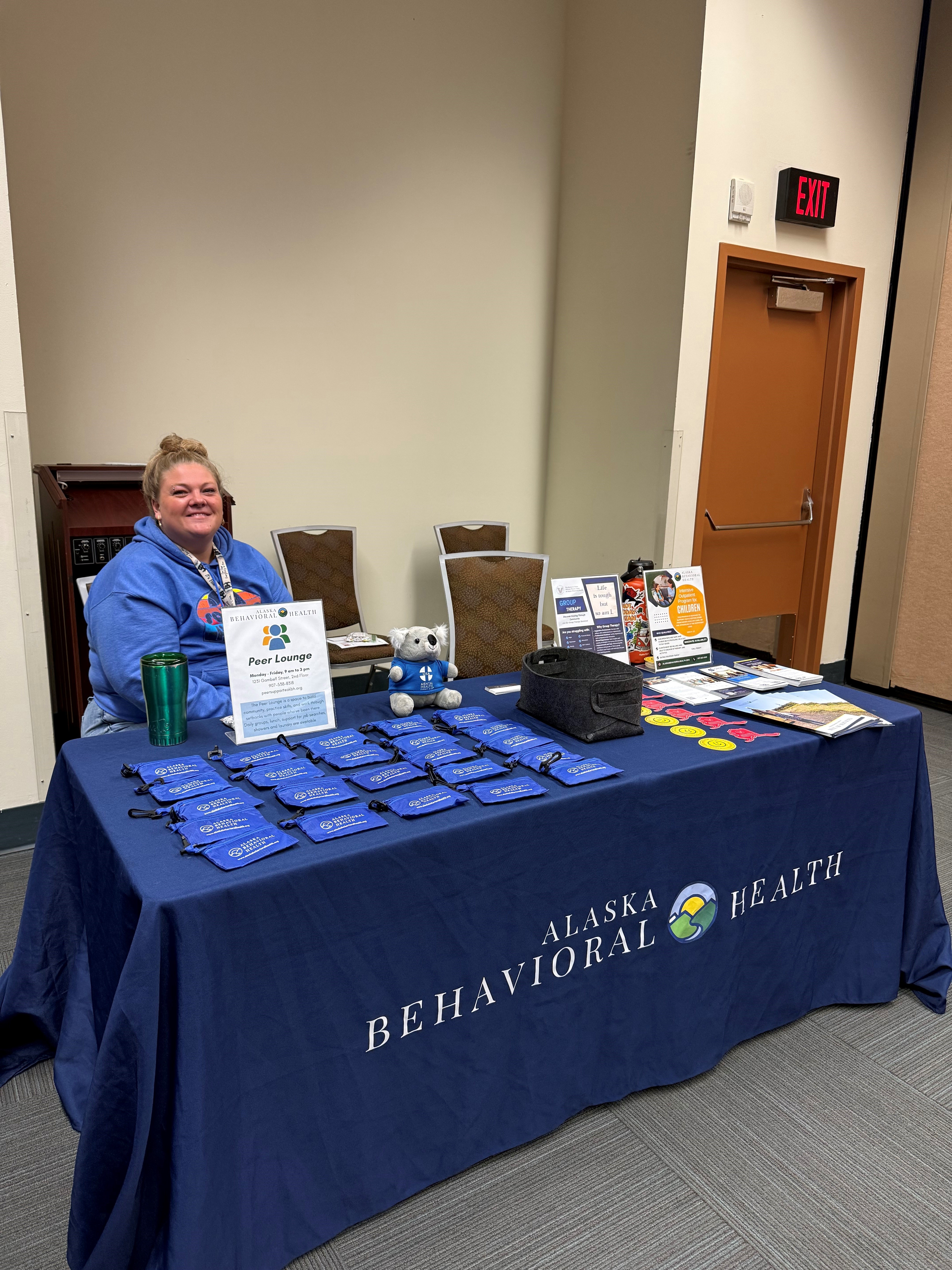 woman in blue sweatshirt at table at event